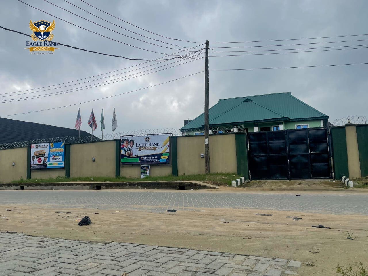 The school gate, flags and admissions signboards
